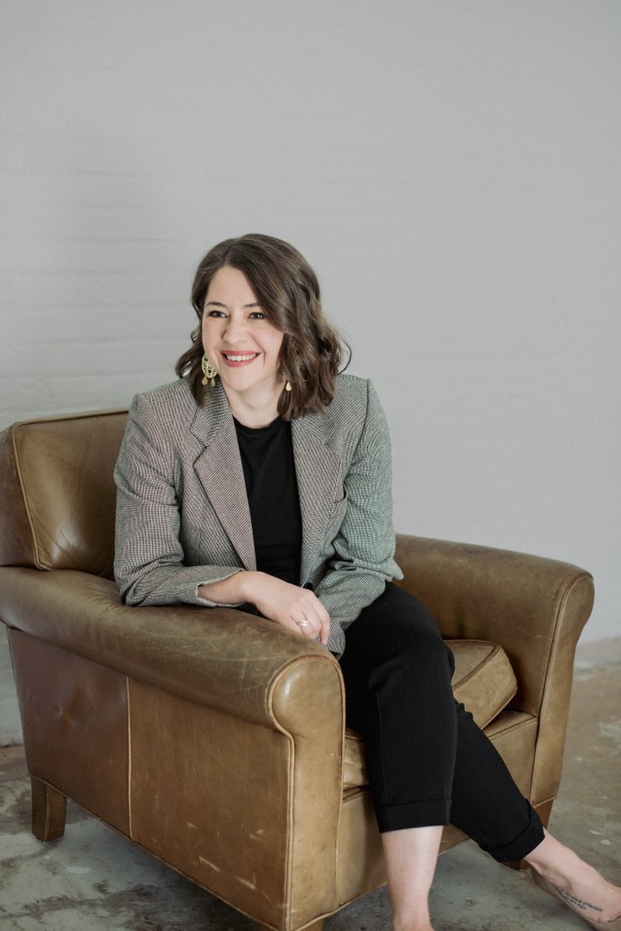 Bethany sitting in an arm chair, smiling